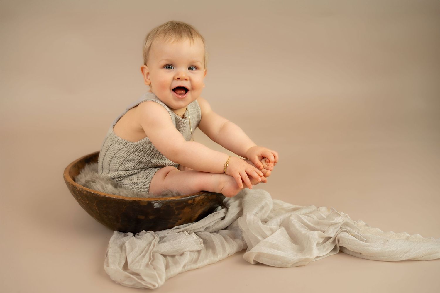 Ettårsfotografering i studio i Sandnes. Blid gutt i trebolle, naturlige farger.