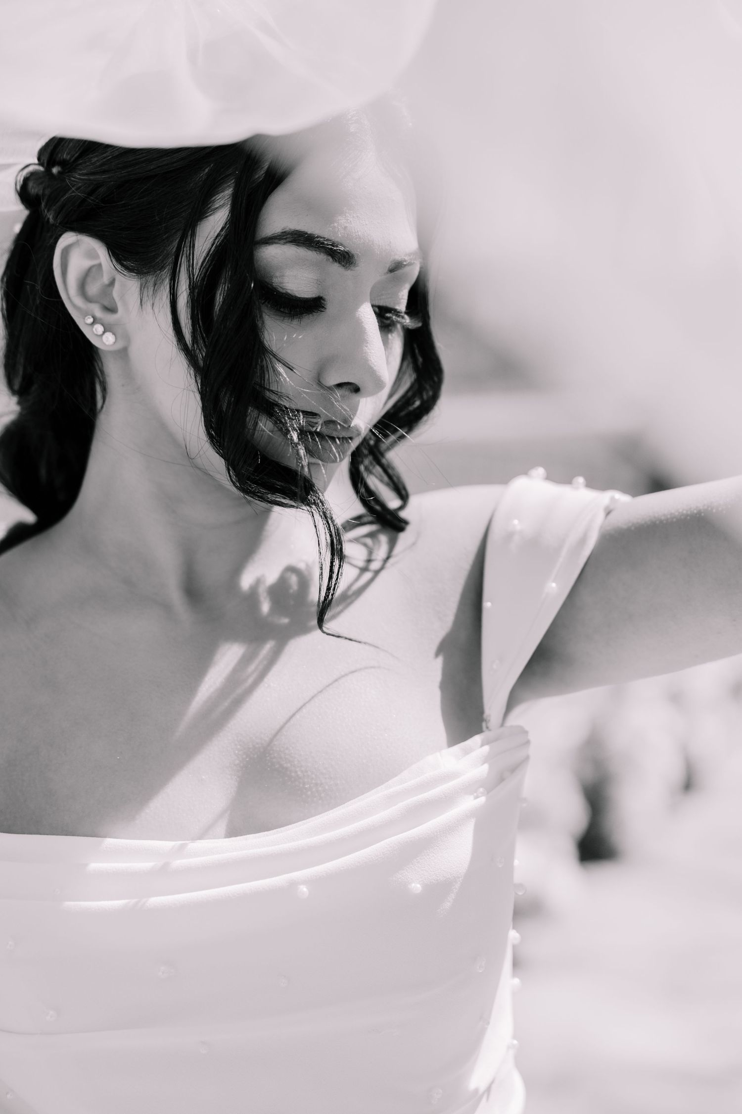 Artistic black and white bridal portrait with soft natural lighting.