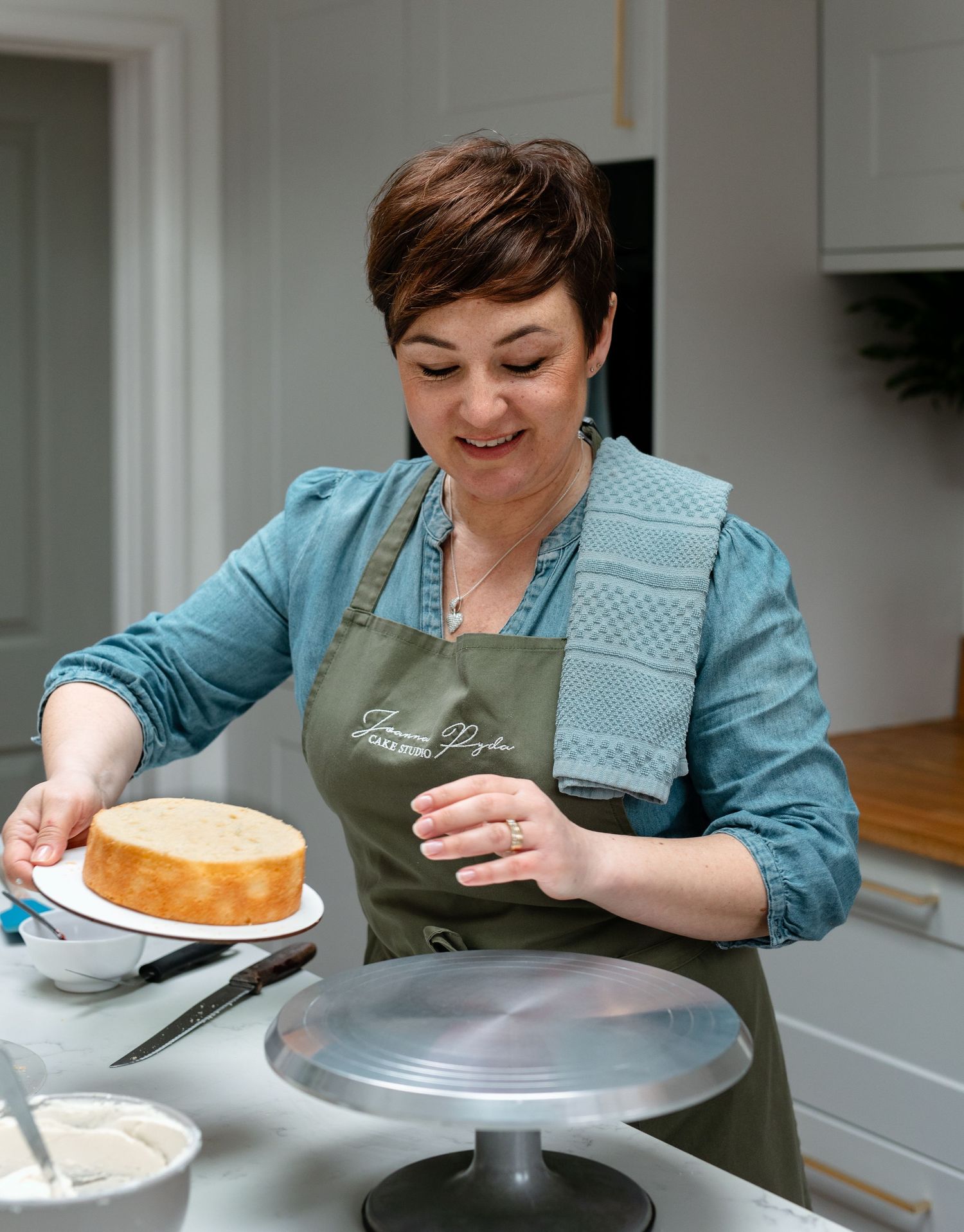A series of images showing someone frosting a layer cake with white icing using an offset spatula and turntable.