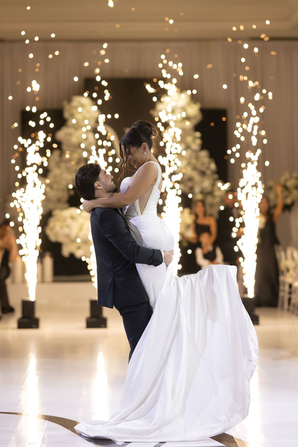 A romantic first dance at a wedding with sparklers creating a magical backdrop of light and shimmer.