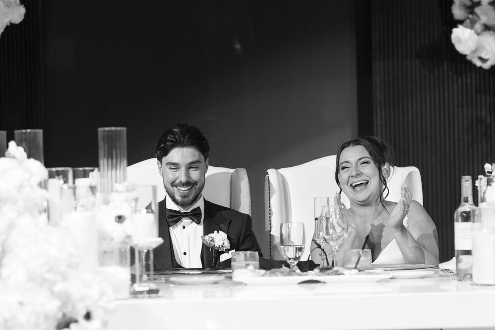 Wedding guests seated at long tables during a reception celebration.
