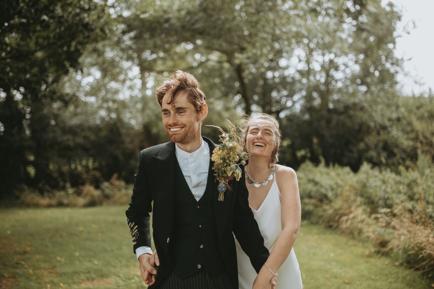 A joyful couple shares intimate moments in a garden setting during their wedding celebration.