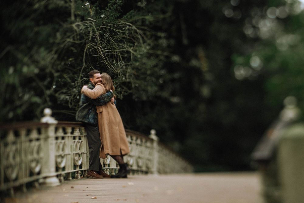 A couple embraces in a dreamy outdoor setting with soft bokeh lighting.
