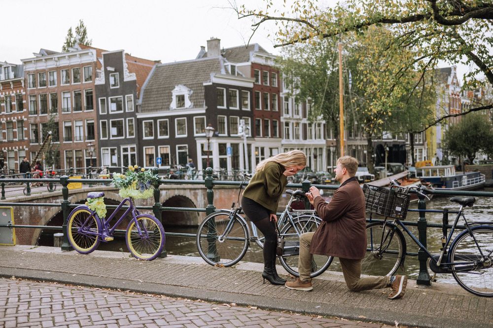 Classic Amsterdam canal scene with bicycles parked along the waterway.
