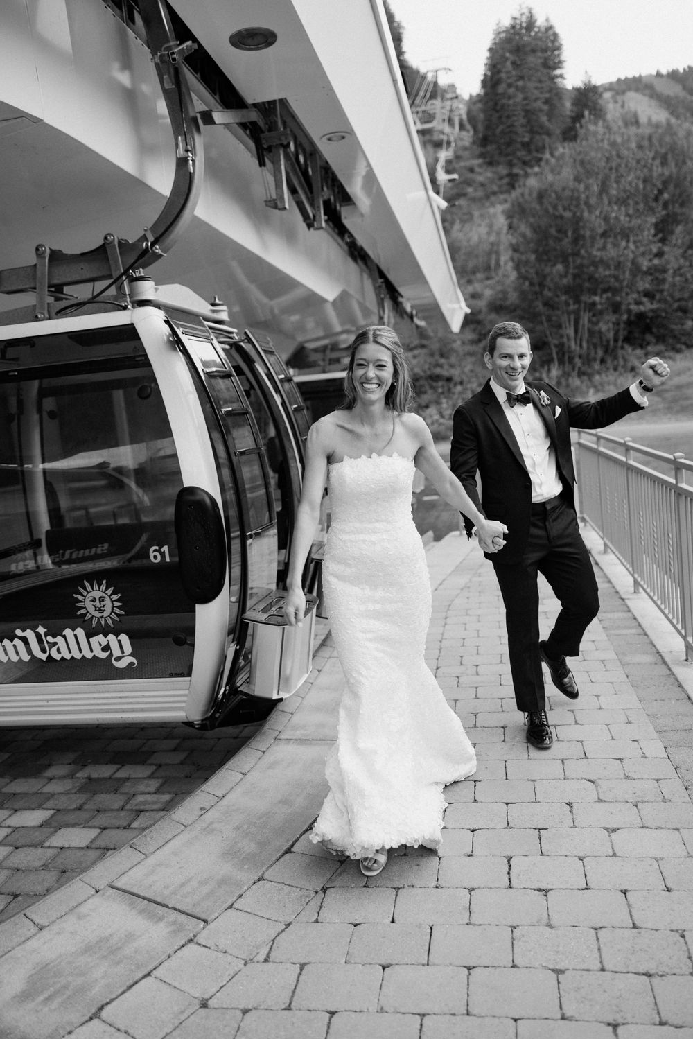 Black and white sequence of a couple playfully running and jumping on a stone patio during their wedding day.