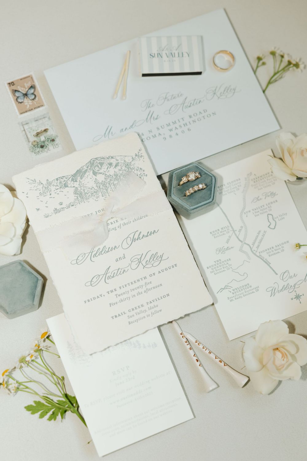 Elegant wedding invitation suite in white and gray with floral details and vintage styling.
