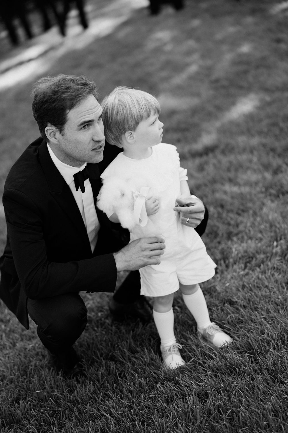 A black and white photo sequence shows a couple sitting in grass sharing a tender romantic moment.