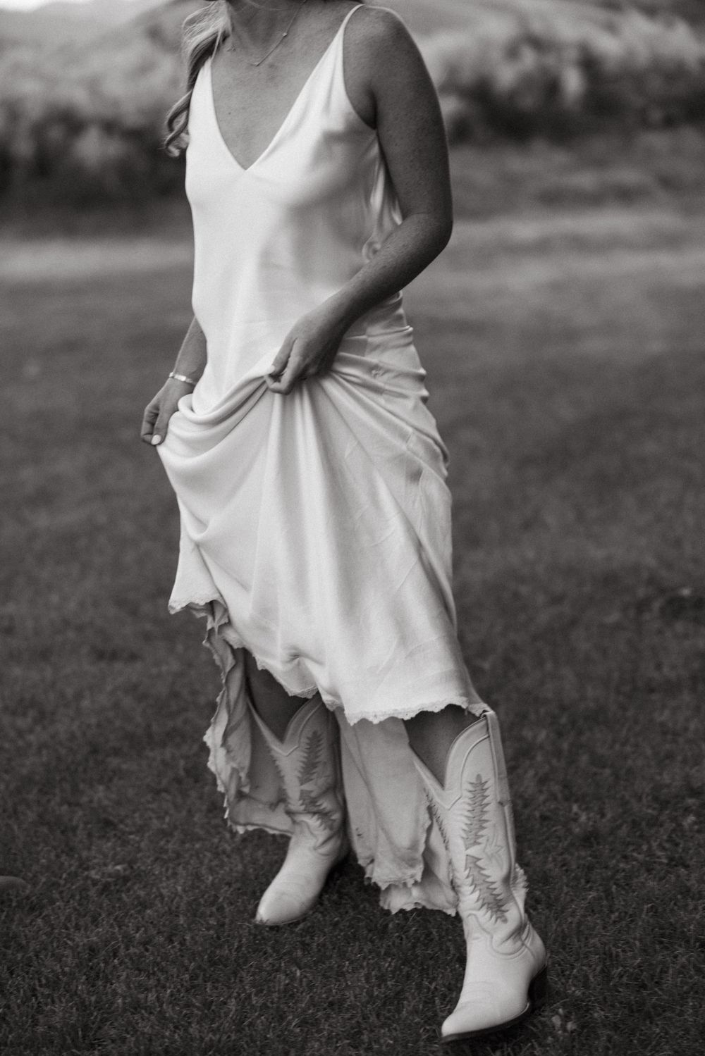 A series of black and white photos showing white boots and dress details against a grassy background.