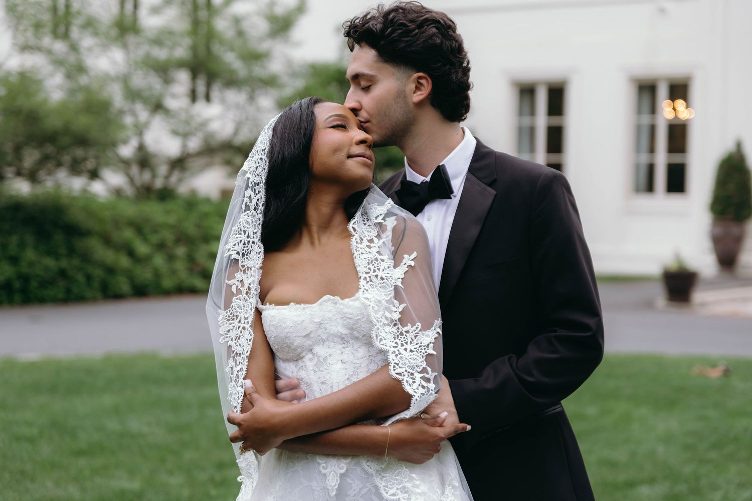 Romantic wedding portraits captured outside a white colonial-style building.