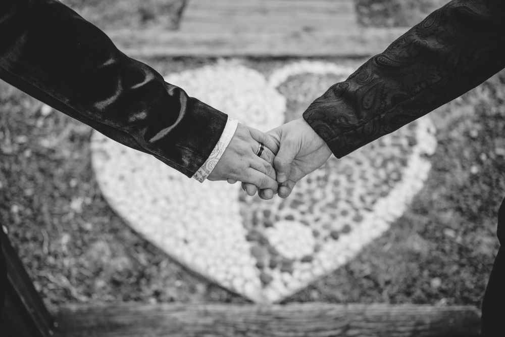 Two hands join together against a background featuring a heart shape in black and white.