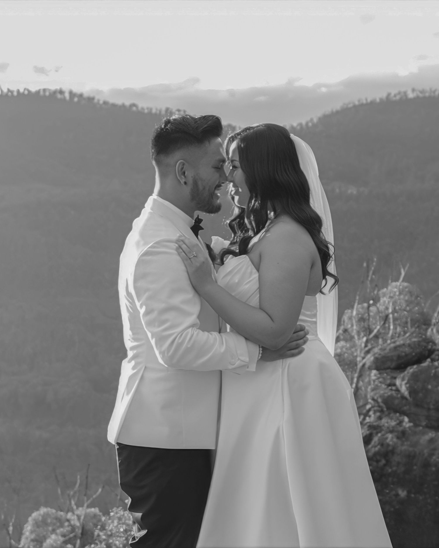 A romantic mountain wedding portrait with dramatic landscape views in the background.