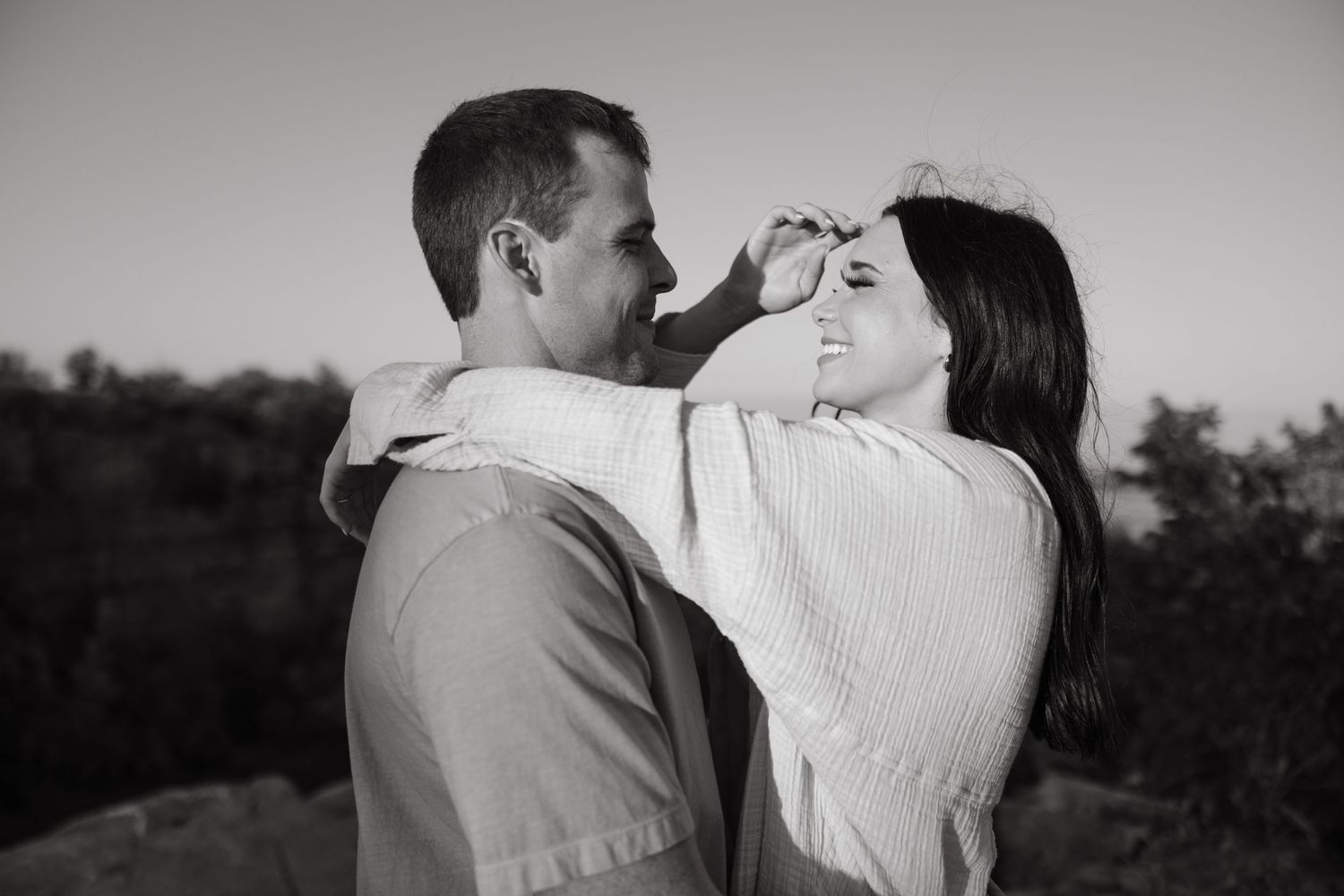 A romantic black and white portrait of a couple sharing an intimate moment.