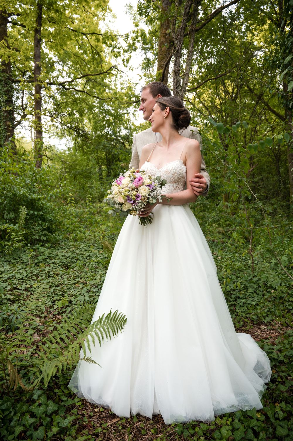 Au Mont des Pins à Barvaux, couple de mariés photographié lors d’une séance photo de mariage en forêt