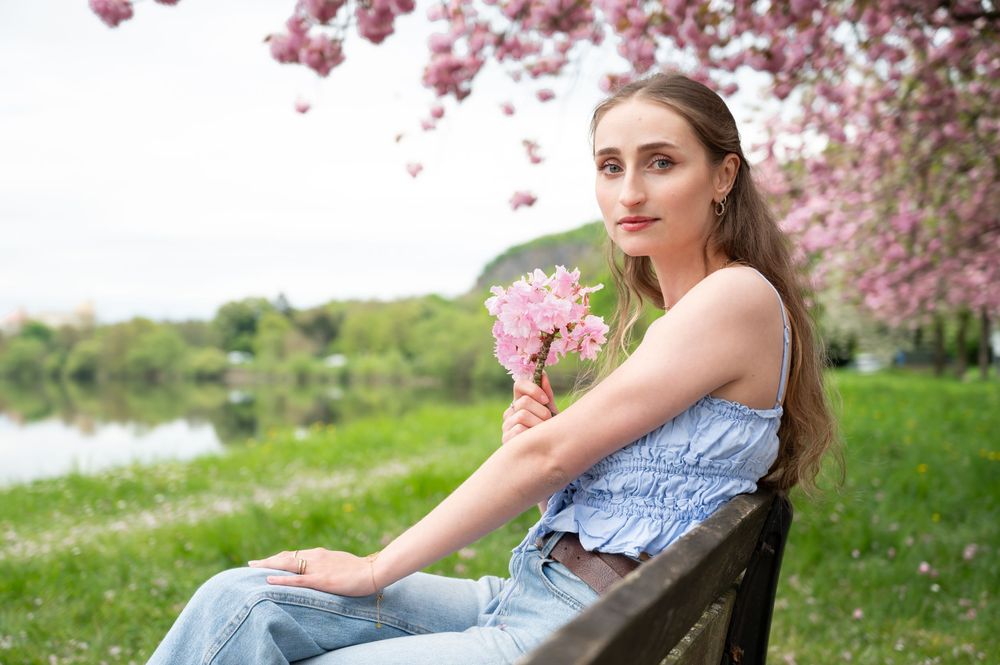 À Huy, portrait d’une femme photographiée sous un cerisier japonais en fleurs lors d’une séance photo au printemps