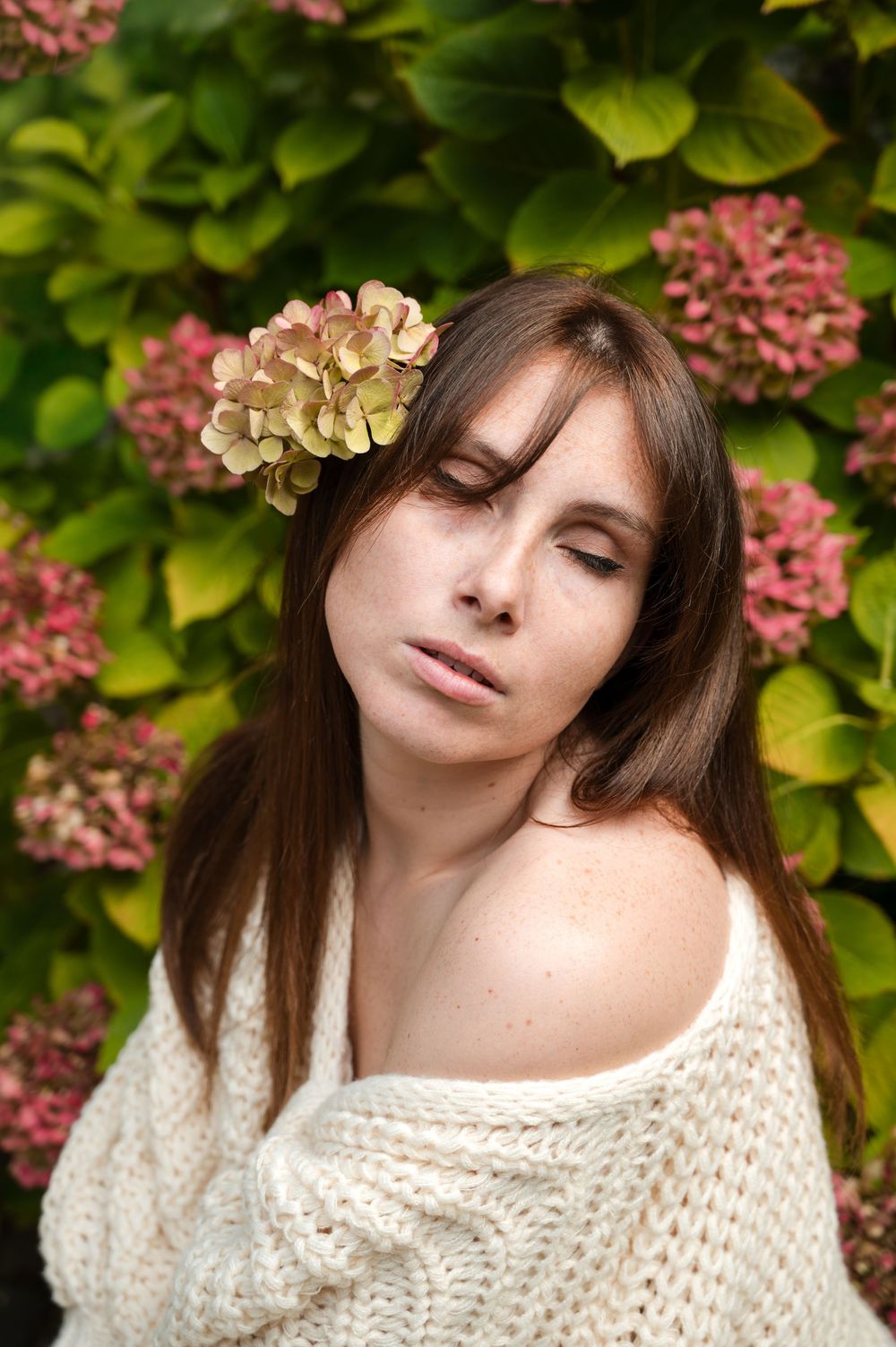 À Huy, portrait individuel d’une femme photographiée devant un fond floral composé d’hortensias lors d’une séance photo