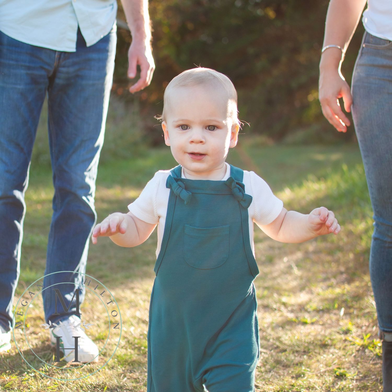 image of toddler walking near parents photo