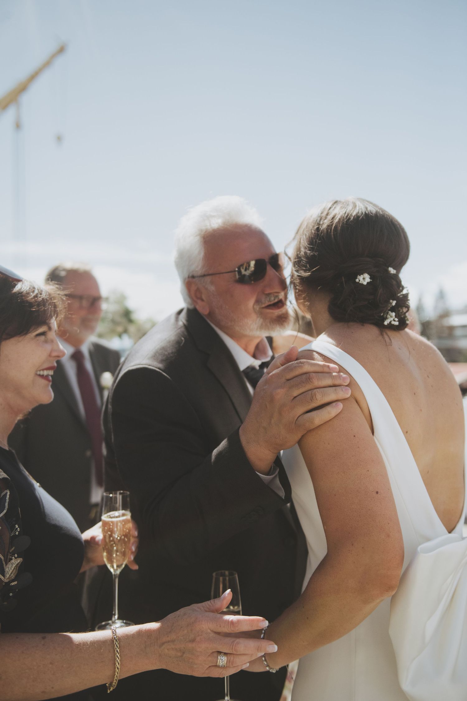 Wedding guests share celebratory moments during an outdoor reception.