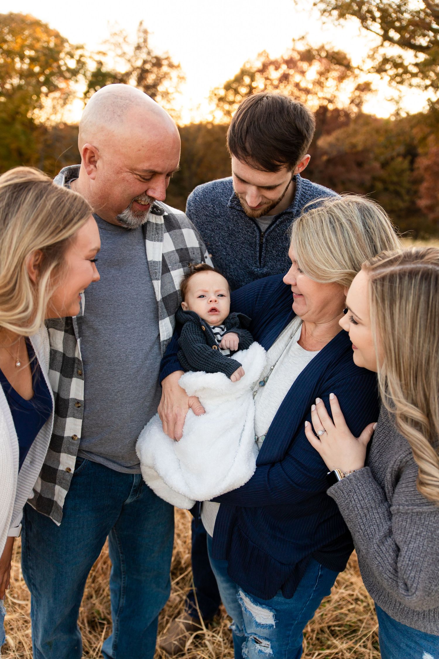 Candid family photo session at sunset with coordinated navy and grey outfits.