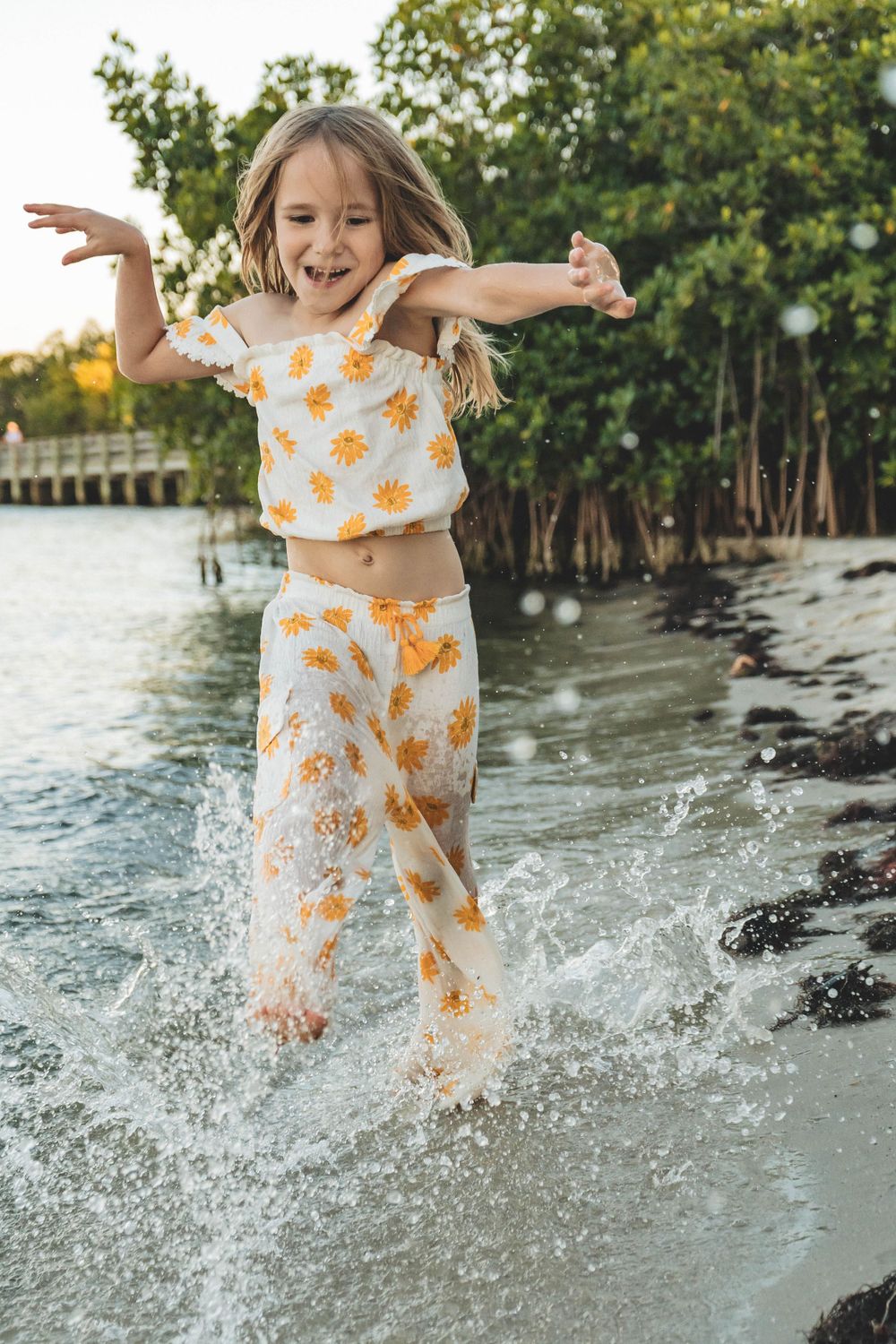 Young girl frolicking through the water at the beach during a family session in palm bay florida