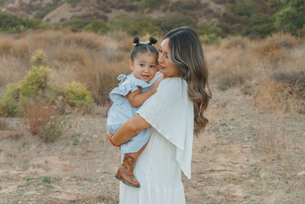 A tender moment captured outdoors against a natural desert landscape.