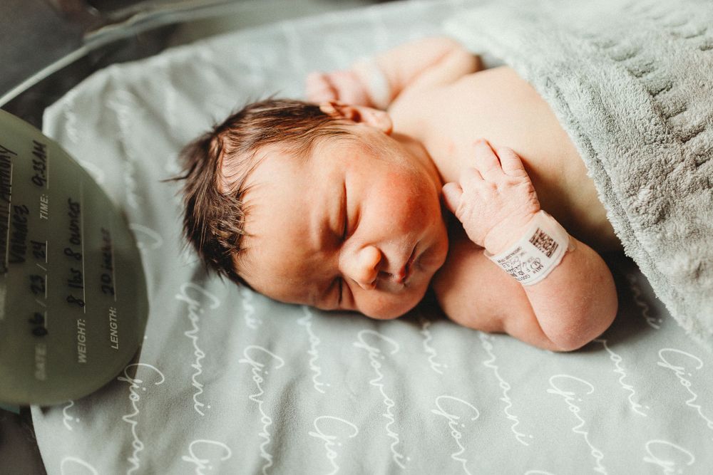 Newborn baby boy getting warm for fresh 48 session