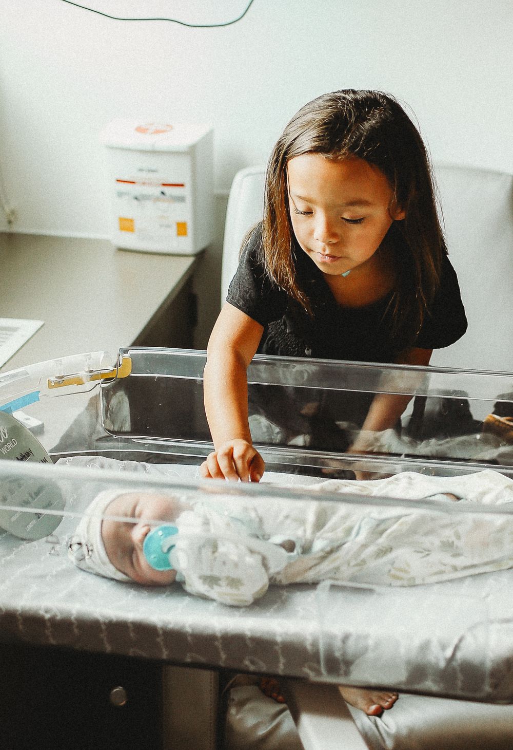 Big sister looking over baby brother in hospital for Fresh 48