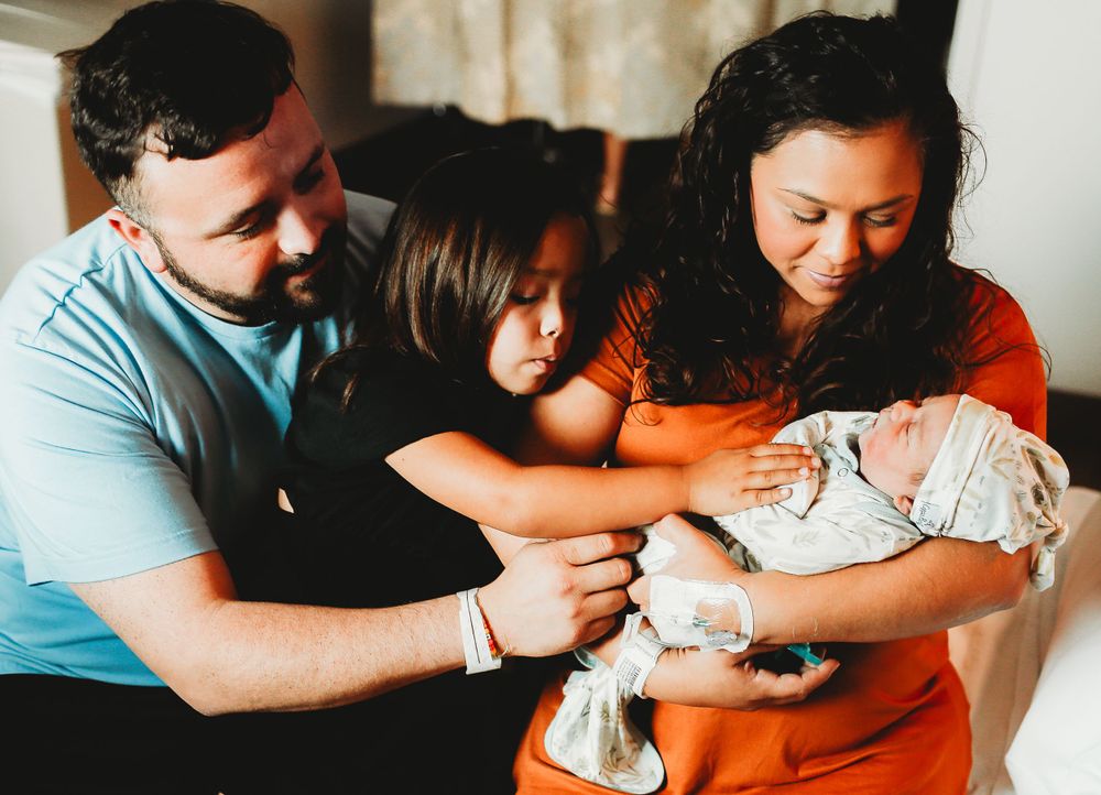 Family posing in hospital with newborn baby boy for family photo for fresh 48 session