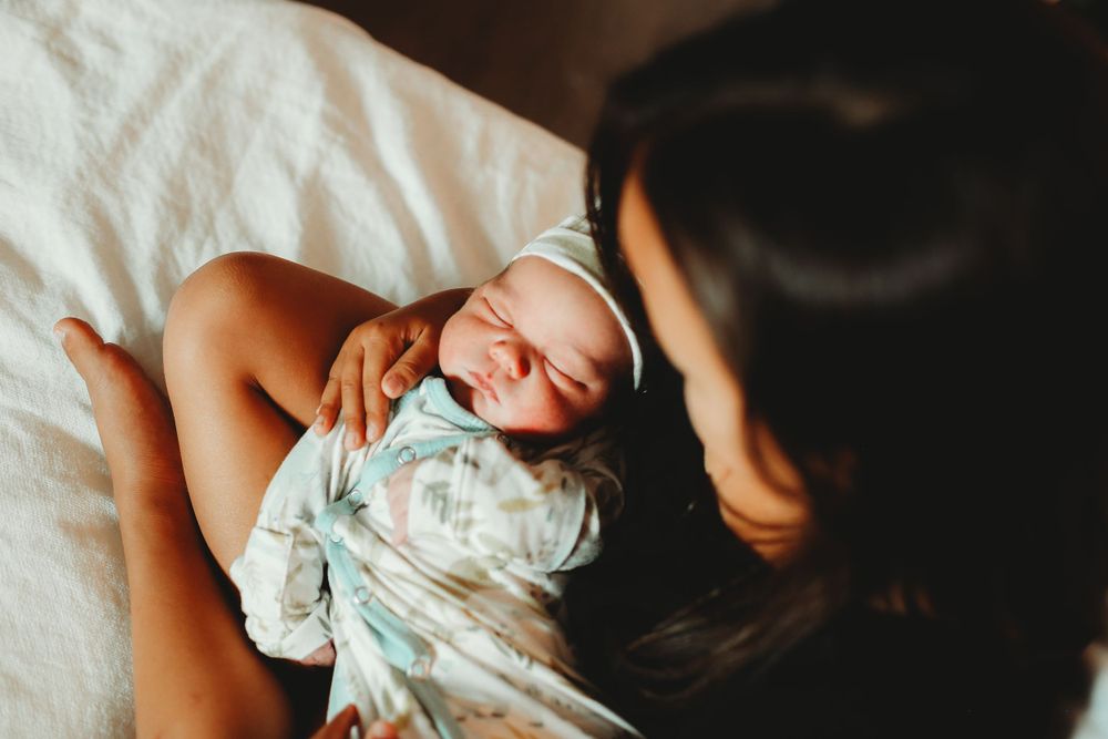 Big sister holds new brother in bed for fresh 48 session