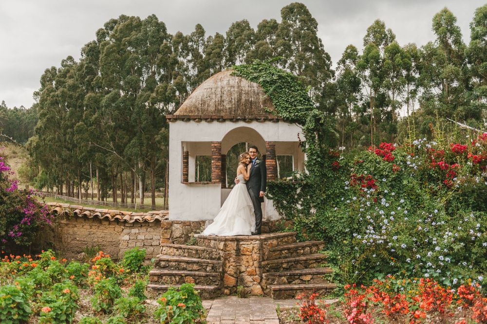 Newlyweds standing on a colonial Colombian garden.