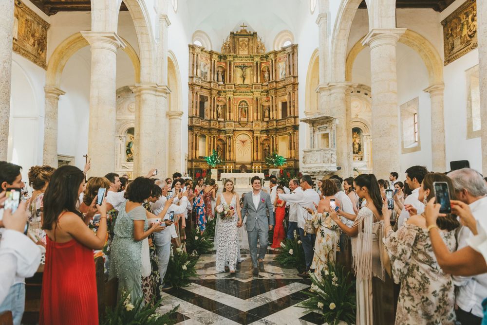 Newlyweds exiting a church surrounded by loved ones in Cartagena.
