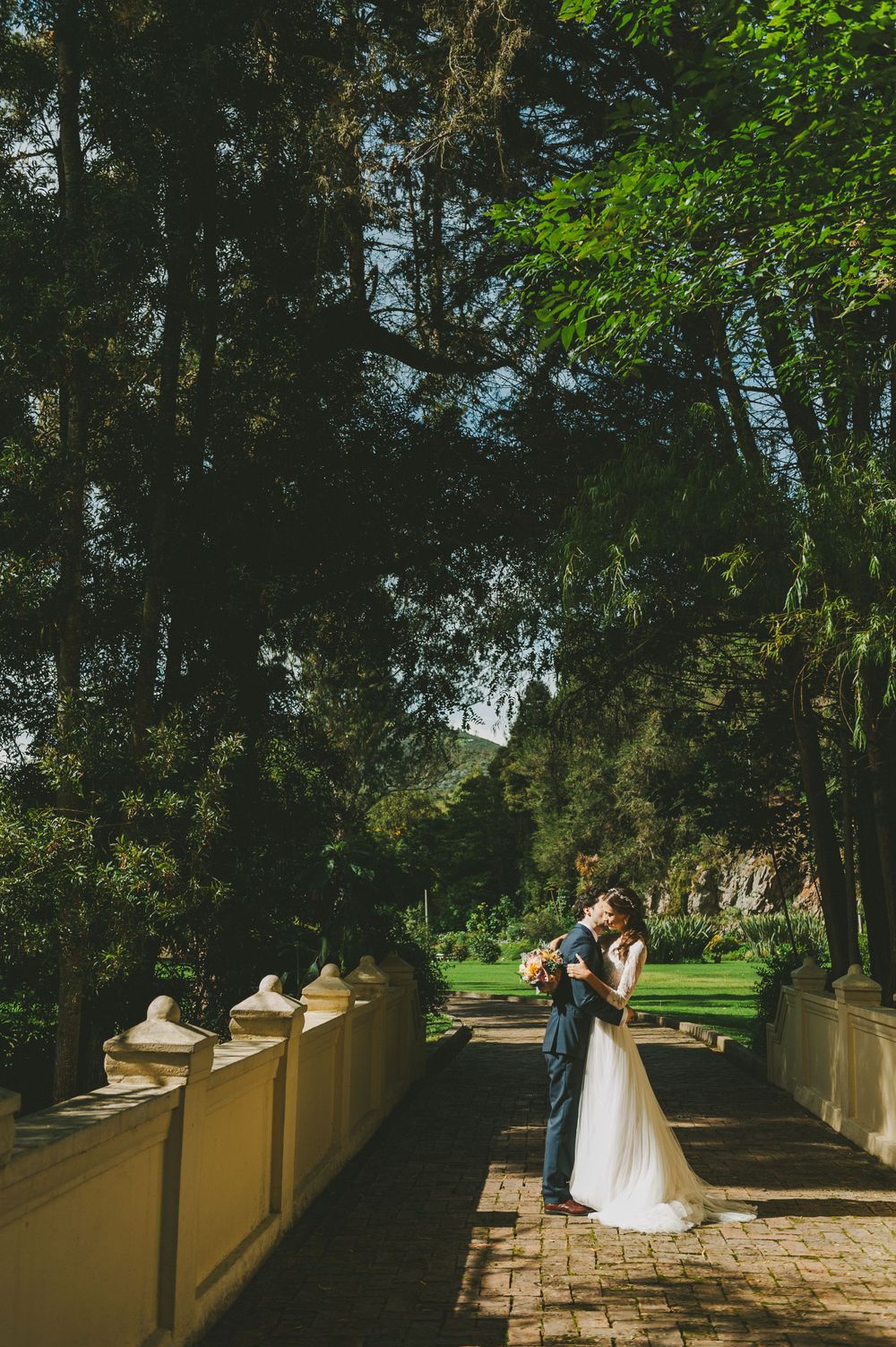 Newlyweds kissing and hugging after wedding ceremony.