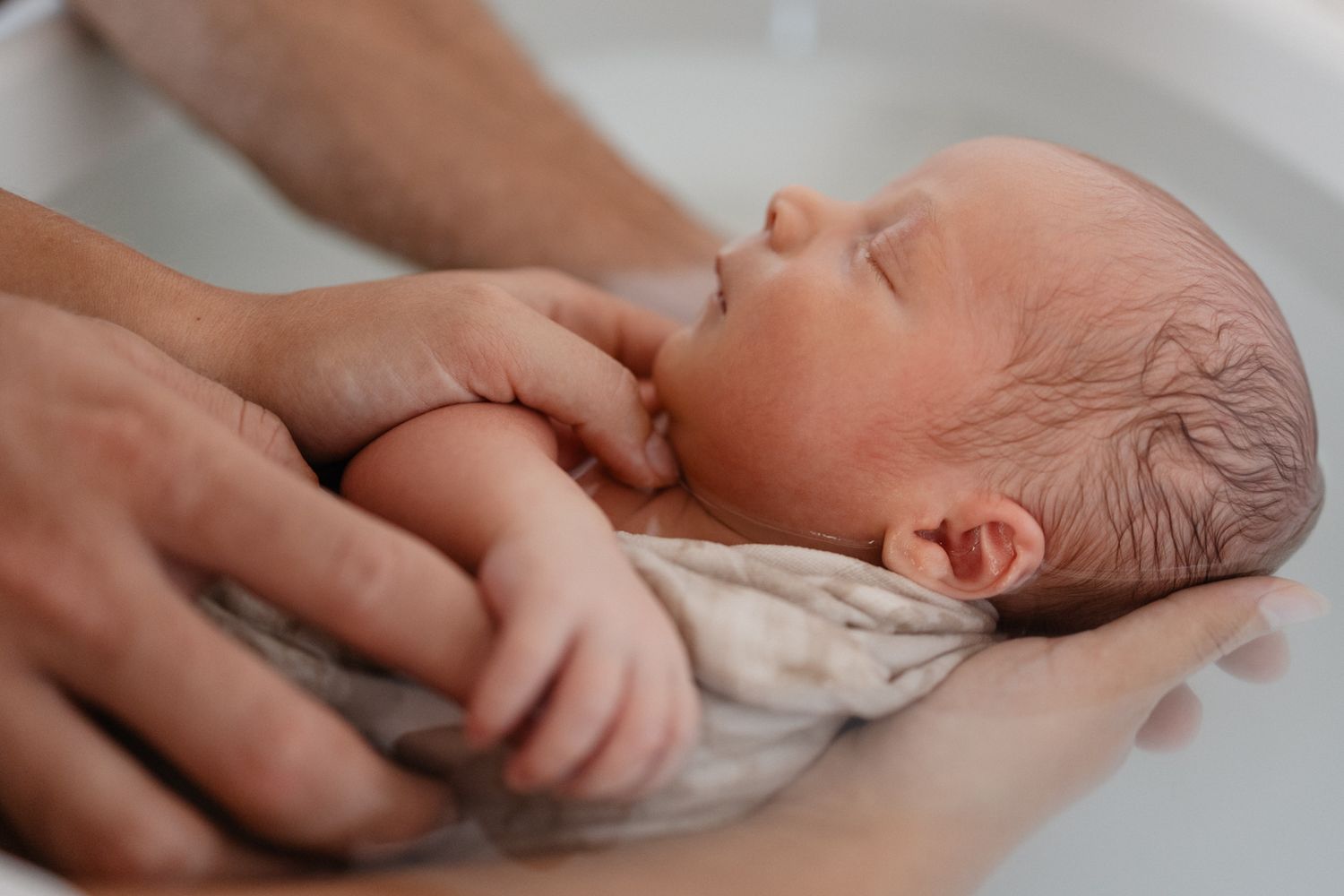 bebe detendu dans les mains de ses parents pendant un therapeutique bain bebe au cabinet un mere veilleux moment avelin