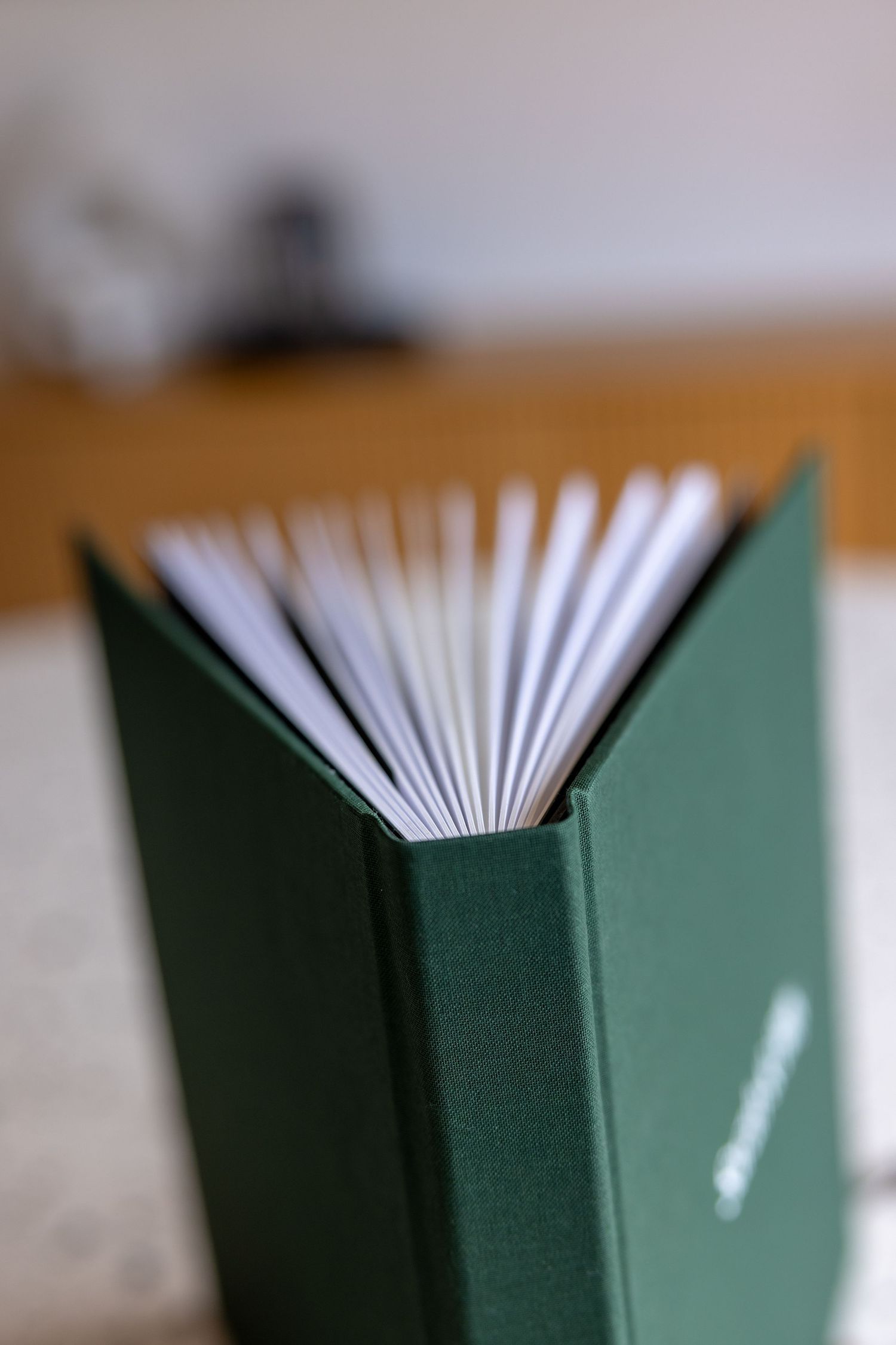 Close-up macro shots show a progression of pages in a green hardcover book fanning out from different angles.