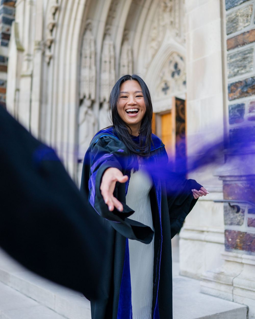 A sequence of celebratory poses in a blue graduation gown against a gothic stone building backdrop.