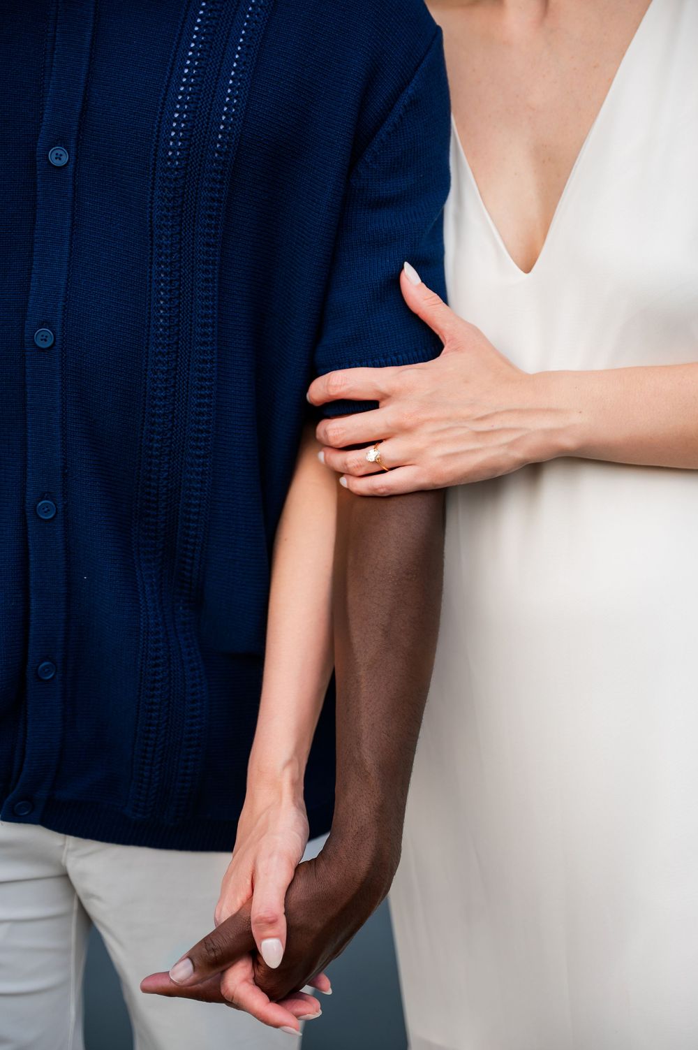 Close-up of hands touching in intimate couple portrait session.