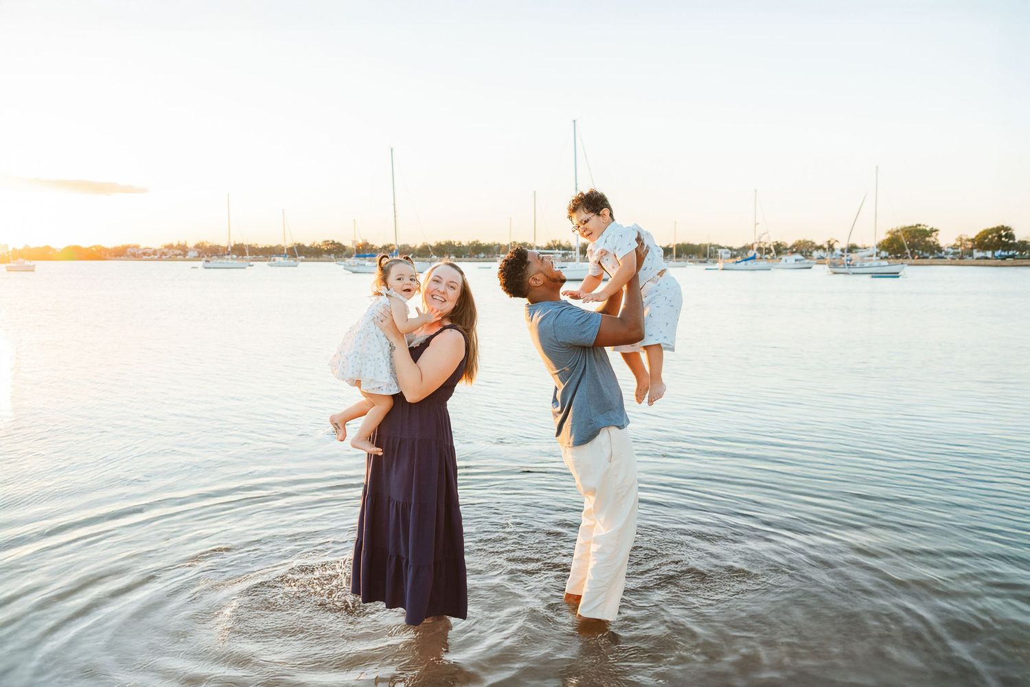 Family standing together near the water during a lifestyle family photography session.