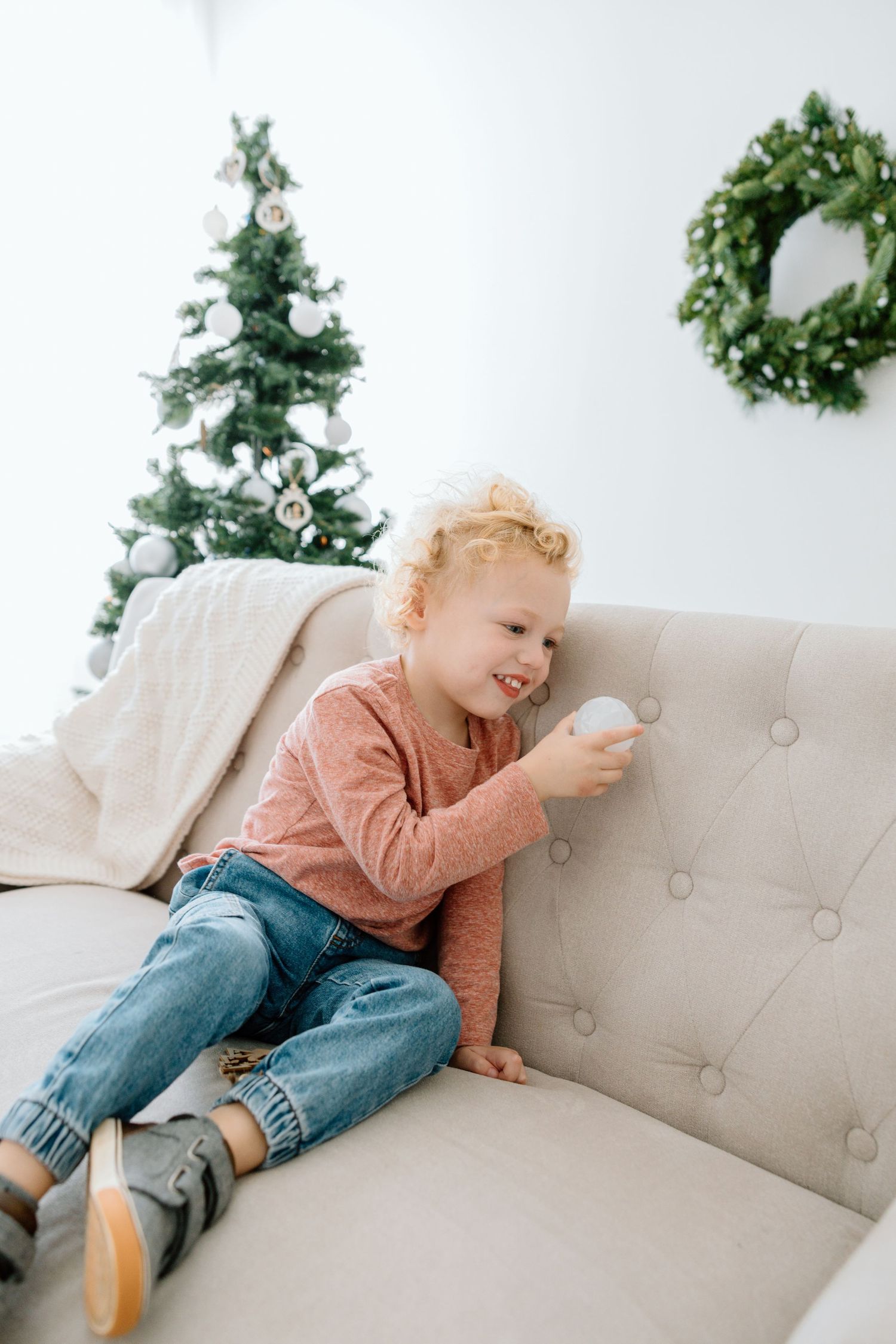 Toddler sitting on a couch during an in-home lifestyle photography session.