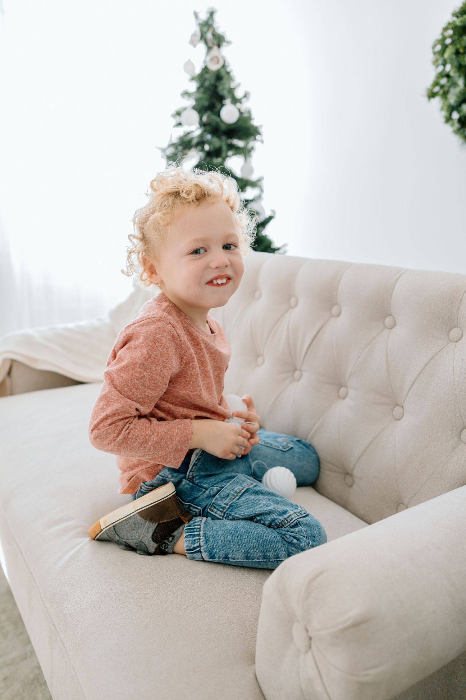 Toddler sitting on a couch during an in-home lifestyle photography session.