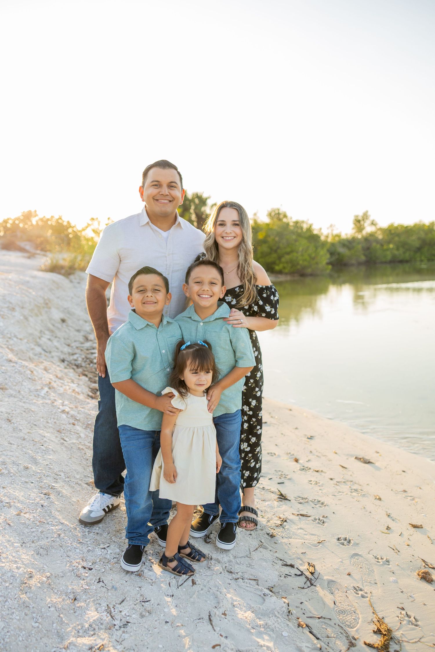 Family standing together in a grassy field during a lifestyle photography session.