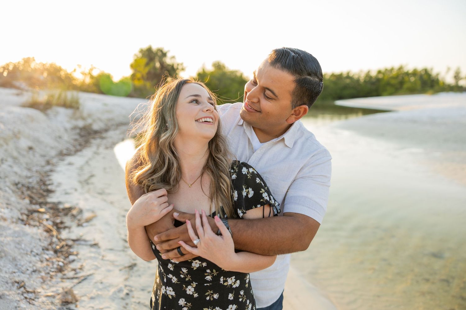 Couple laughing together by the water during a lifestyle couples photography session.
