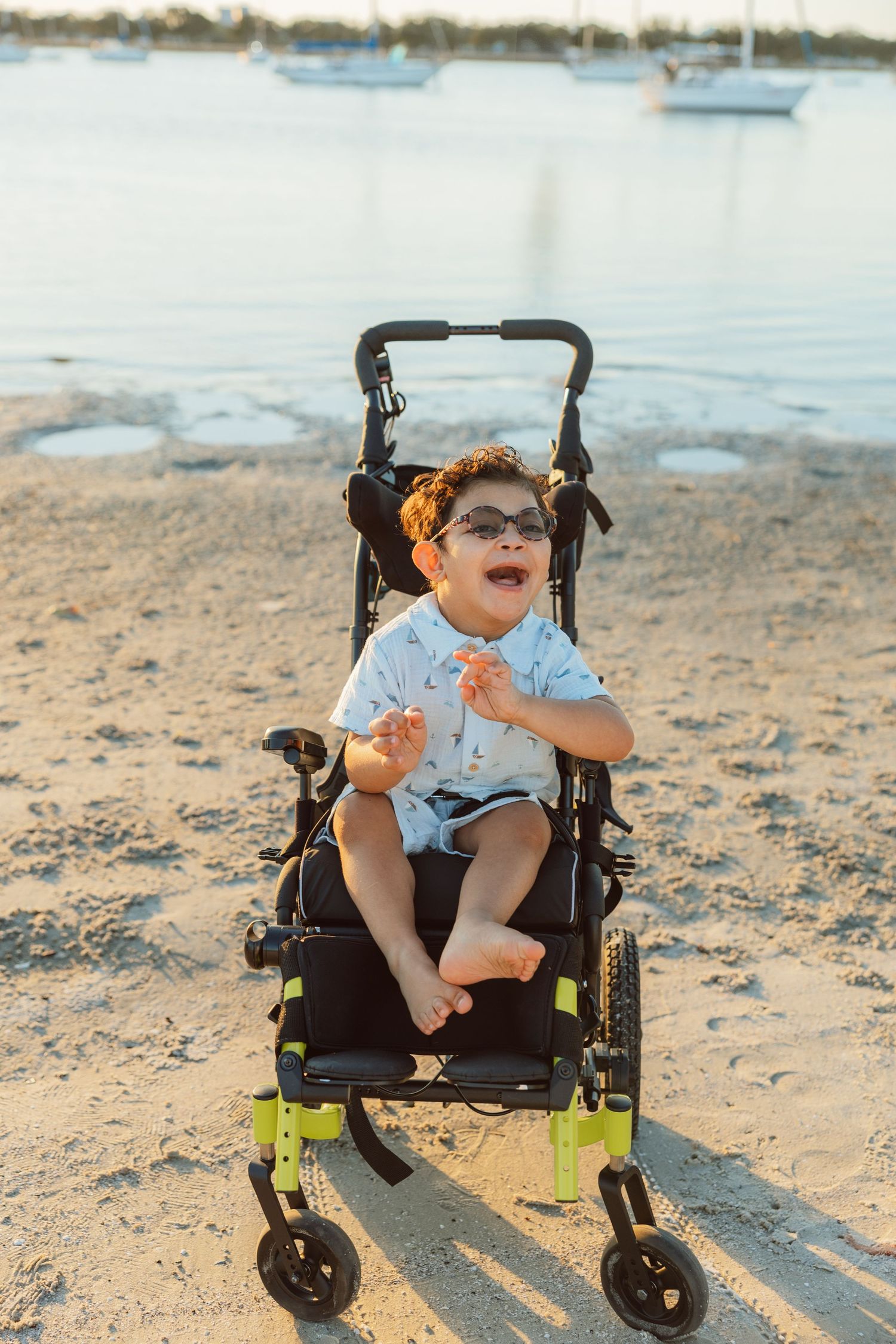 Child sitting in a stroller on the beach during a lifestyle family photography session.
