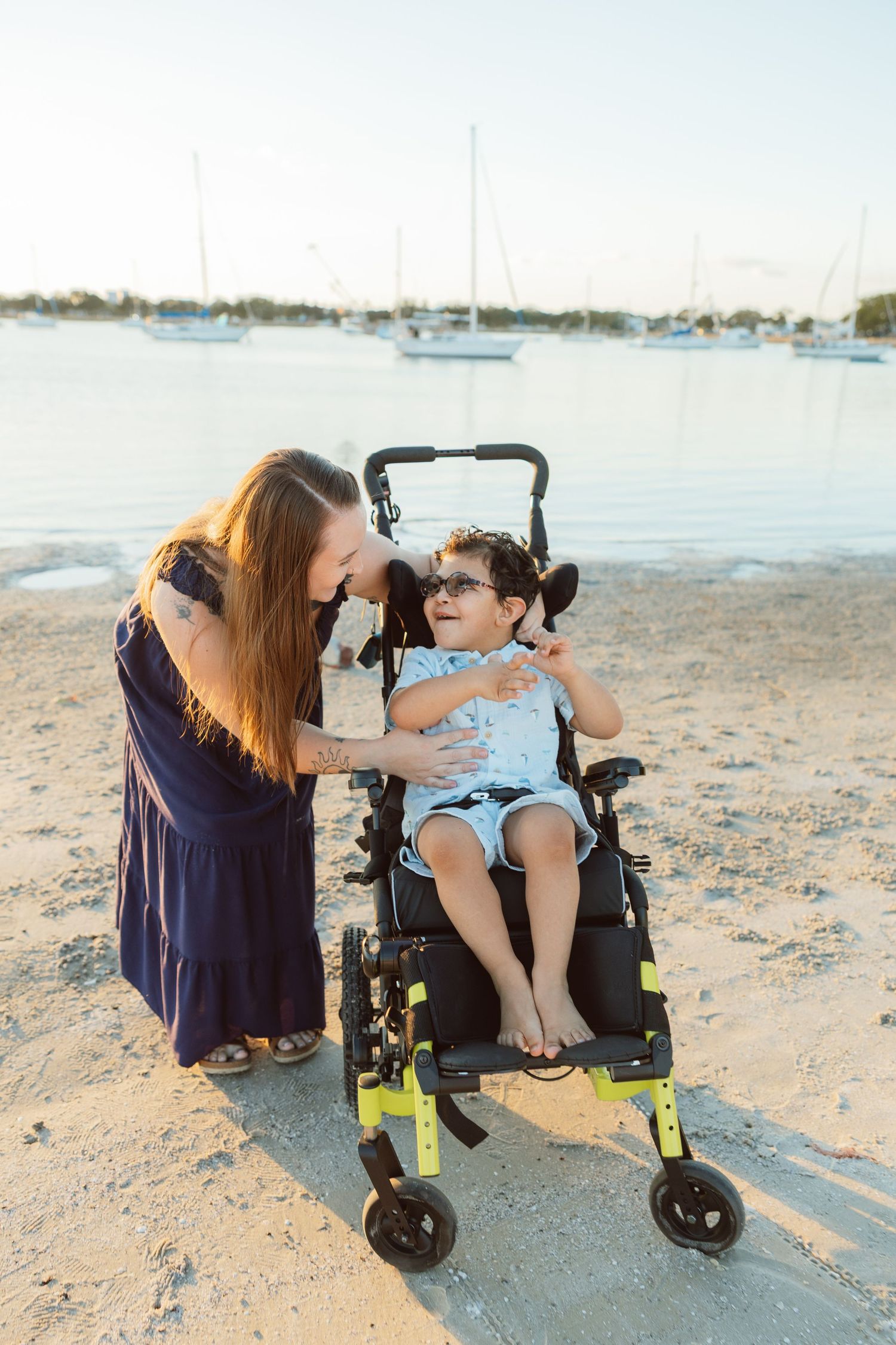 Child sitting in a stroller on the beach during a lifestyle family photography session.