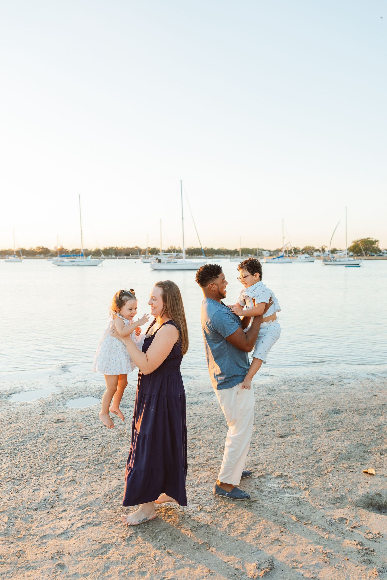Parents holding their children on the beach during a lifestyle family photography session.