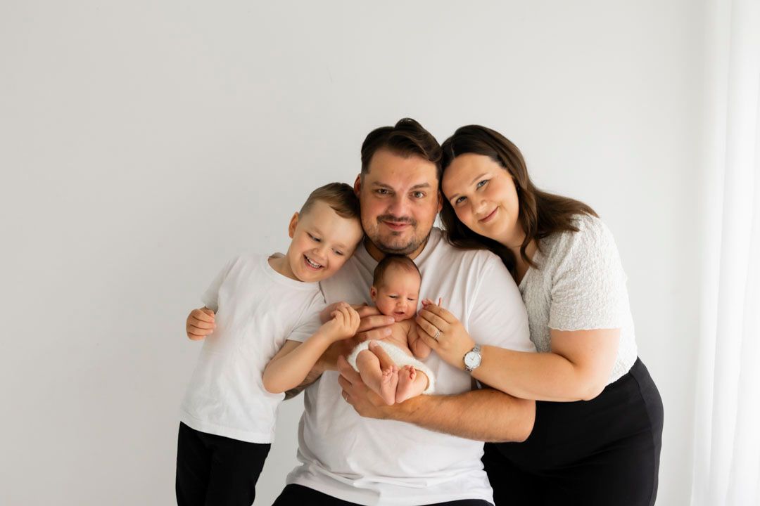 kaksi lasta, äiti ja isä perhekuvassa, newborn kuvauksessa studiolla