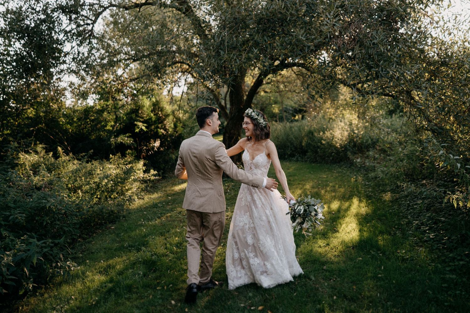 A romantic outdoor photoshoot captures tender moments between a couple in a sunlit wooded setting.