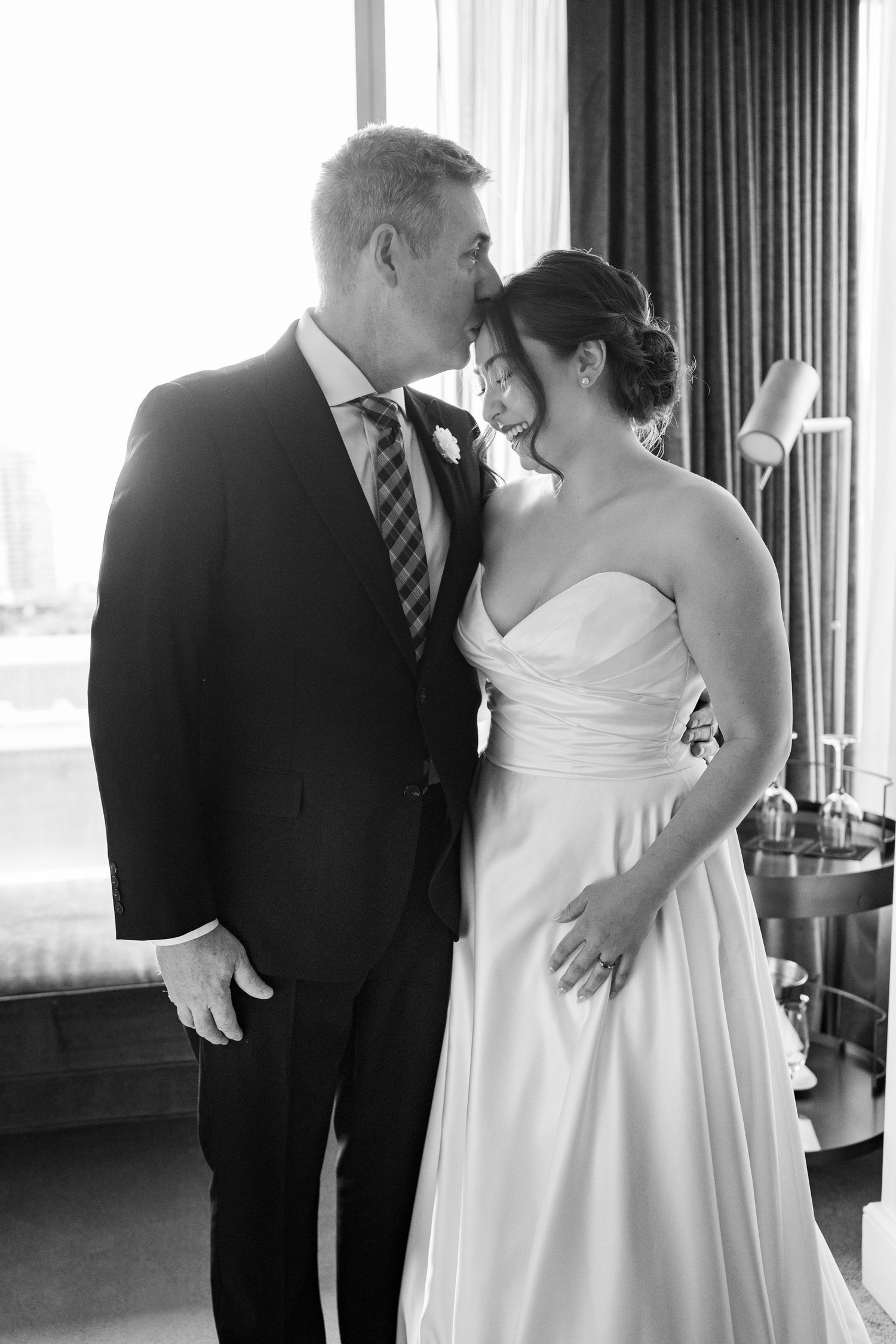 A wedding couple shares a playful moment cutting their cake together in a reception venue.