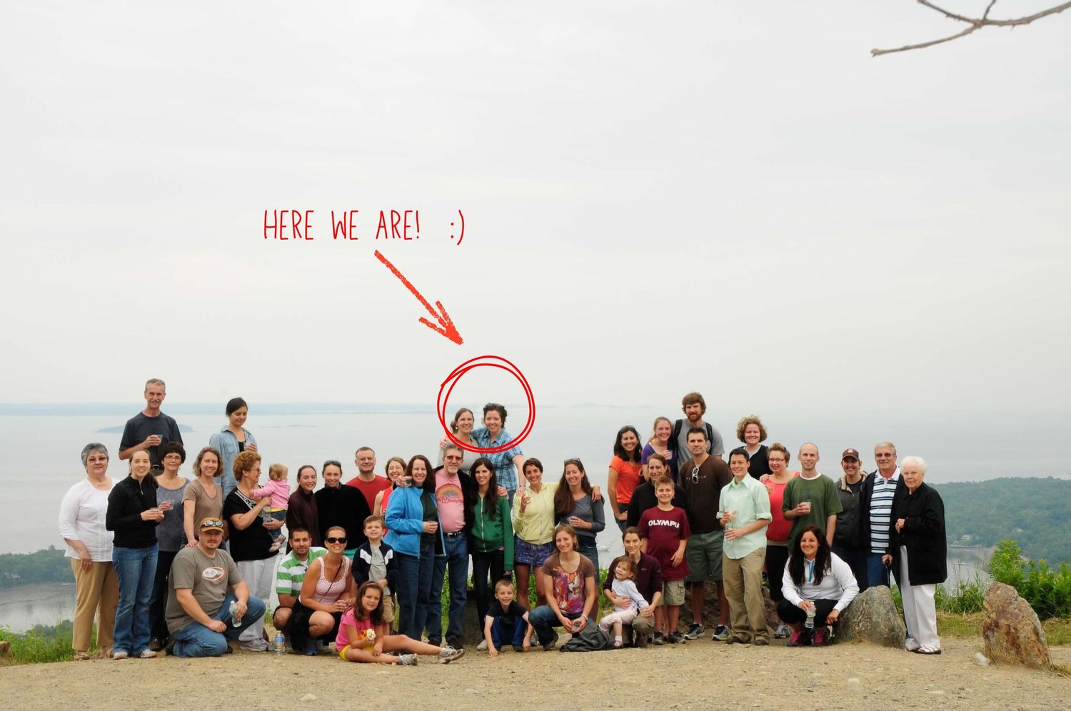 A panoramic group photo of people gathered at the top of Mount Battie in Camden, Maine.  The group is celebrating after a wedding.