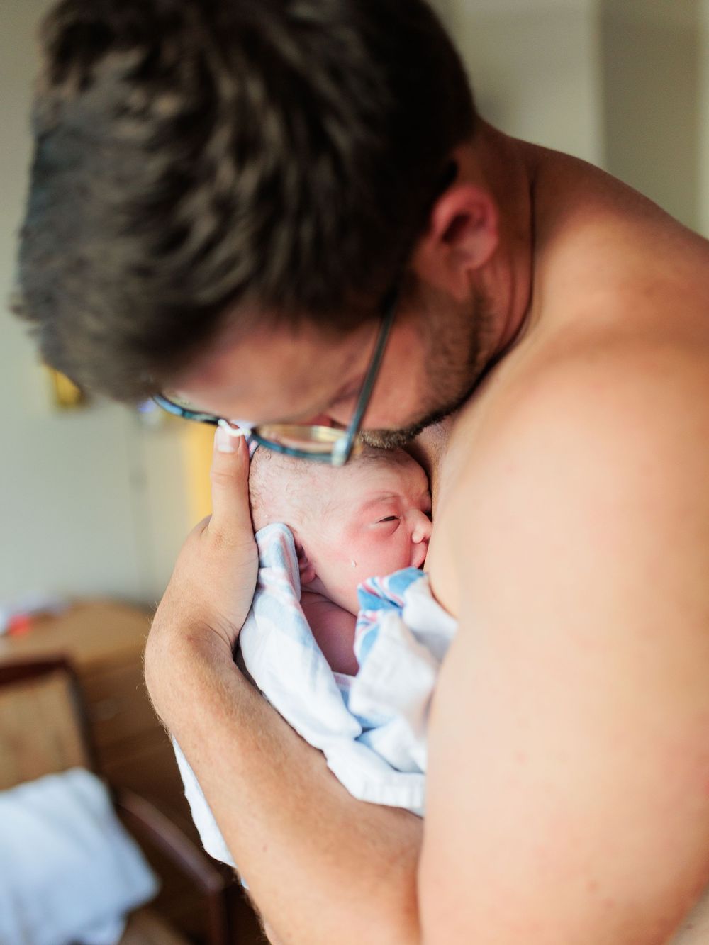 Dad snuggling baby after birth