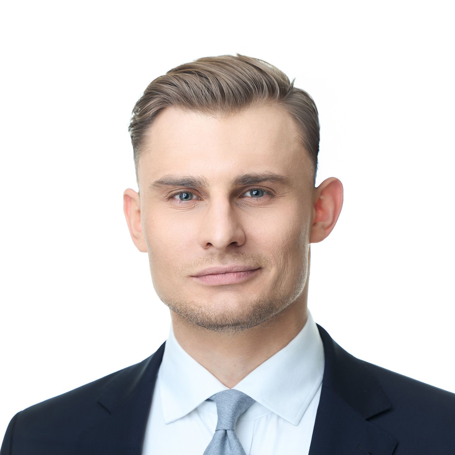 Profesjonalny portret osoby w granatowym garniturze i błękitnym krawacie. Fotografia biznesowa Lublin.