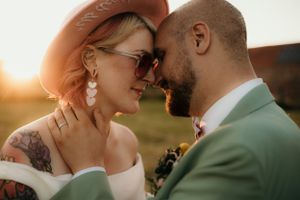 Intimate moment between couple in formal wear during golden hour sunset.